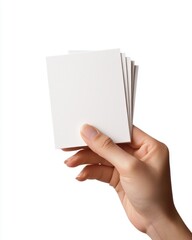 Obraz premium A hand holding a stack of blank cards against a white background.