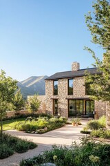 Discover a stunning modern stone house nestled in a picturesque natural setting, embraced by vibrant greenery and majestic mountains beneath a bright, clear blue sky
