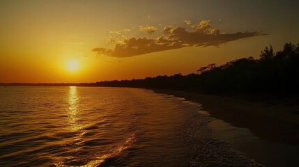 Golden sunset at the beach creating a beautiful orange light reflection on the water