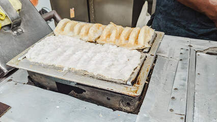 High angle view. The serving process of an authentic Indonesian traditional cake  famously known as Bandros or Gandos. Best served with crystal sugar
