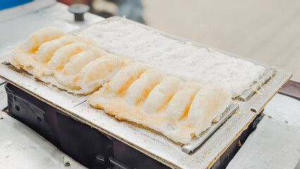 High angle view. The serving process of an authentic Indonesian traditional cake  famously known as Bandros or Gandos. Best served with crystal sugar