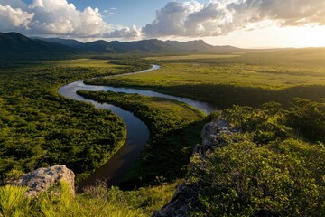 Obraz premium Lush Valley Serenity, expansive landscape showcasing a winding river, vibrant greenery, warm golden hues illuminating the tranquil scene.