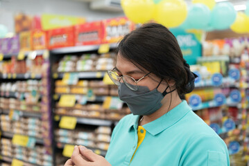 Asian woman work in supermarket or hypermarket is a popular destination for shopping a food and relaxing family.