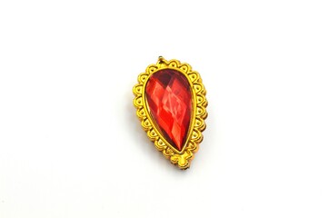 A gold-framed, teardrop-shaped red gemstone brooch