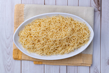 Potato straw or shoestring potato in a plate over wooden table