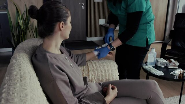 Nurse injecting patient with syringe at home