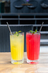 Glasses with summer lemonades with ice and mint on wooden table