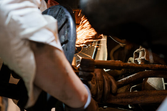 Sparks Flying: A Mechanic Working on a Vehicle's Undercarriage