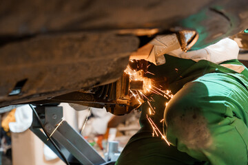 Mechanic Welding Underneath a Vehicle in a Workshop