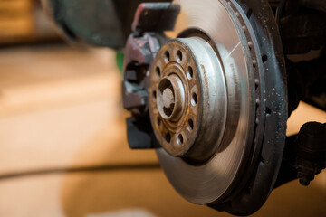 Close-up of a Car Brake Disc and Caliper in a Mechanical Workshop