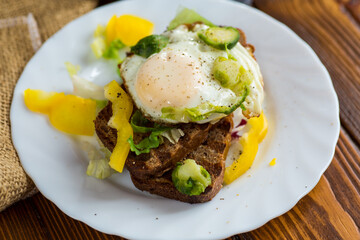 Egg on bread with vegetable garnish