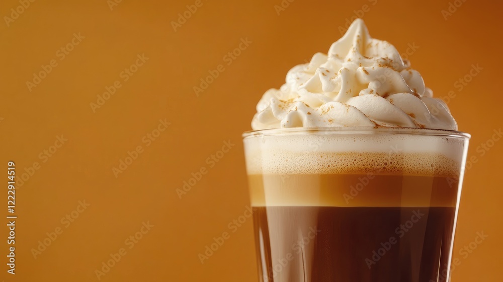 Aufkleber Close up of a creamy topped espresso in a glass with a warm orange background and empty space for text or branding