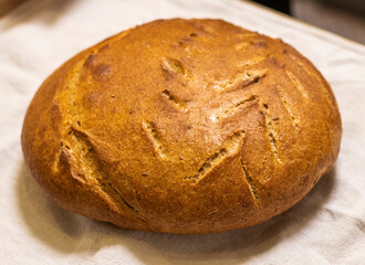 Shot of the freshly baked loaf of home made rye bread on the linen cloth, Food