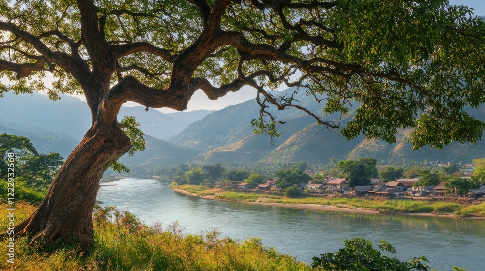Poster Close up of a large tree by a riverbank with scenic mountains in the background and space for text and design elements