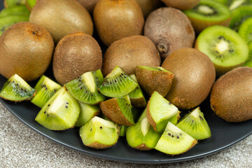 Plate of sliced and whole fresh kiwi fruit.