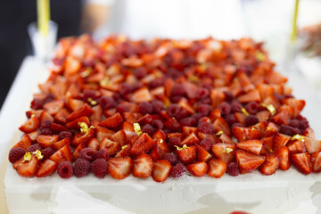 lots of fresh strawberries on a big wedding cake at a celebration
