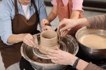 Hobby and craft. Women with girl making pottery indoors, closeup