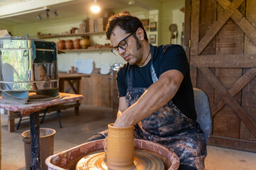 Crafting a Timeless Elegance A Dedicated Potter Skillfully Shaping Clay on the Wheel