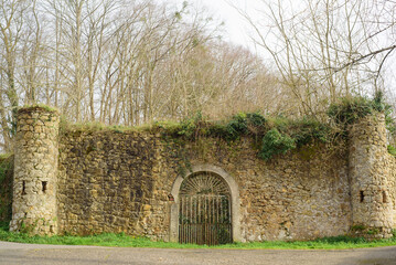Arco en puerta de muralla de piedra en jardín en invierno
