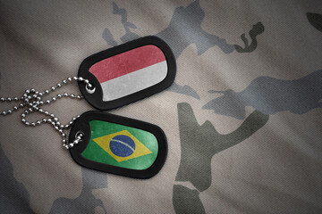 vintage army blank, dog tag with flag of indonesia and brazil on the khaki texture background....