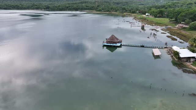 Lake Peten Itza in Guatemala, with a thatched hut perched on a platform extending over calm