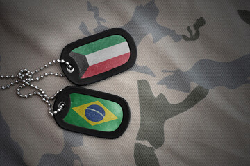 vintage army blank, dog tag with flag of kuwait and brazil on the khaki texture background. military concept.