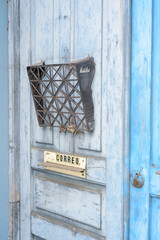 Buzón y cartel de correo en puerta rústica de edificio