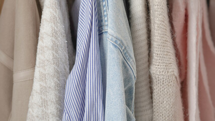 Cozy autumn outfits hanging in a wardrobe, highlighting earthy tones and textures.