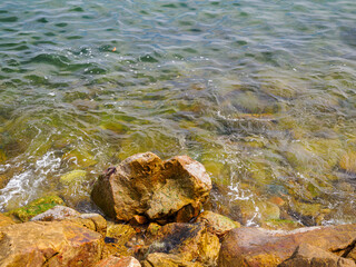 Rocks in the sea crashing against soft waves