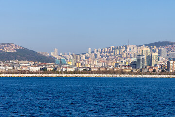 Skyline of Istanbul’s Asian side with modern residential buildings and a rocky shoreline. A vibrant view of the Anatolian side blending urban development and coastal beauty. Panaromic Istanbul 2025