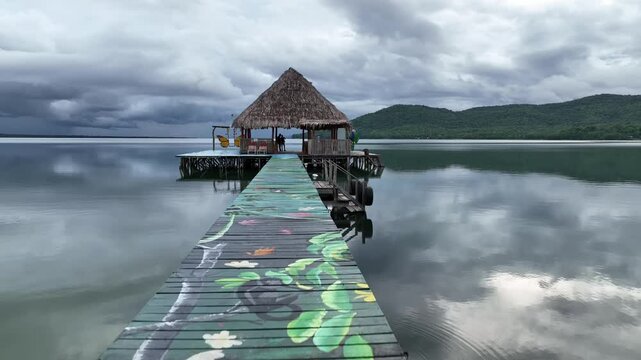 Lake Peten Itza in Guatemala, with a thatched hut perched on a platform extending over calm