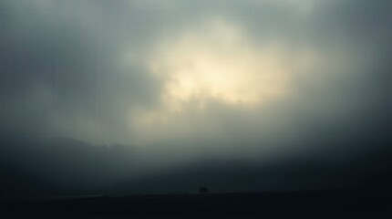 Fototapeta premium Misty Landscape at Dawn with Sunlight Peeking Through Clouds