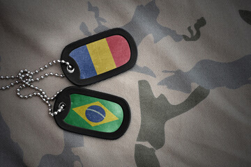 vintage army blank, dog tag with flag of romania and brazil on the khaki texture background....