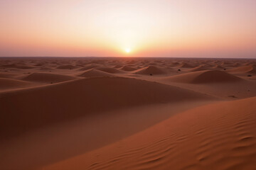 Desert dunes at sunset with vibrant orange and pink sky