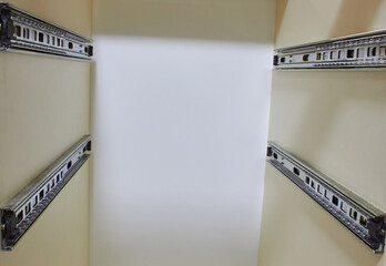 A metal drawer slide rail in furniture, white kitchen cabinet with metal slide guides for drawers,...