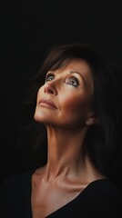 Fototapeta premium Confident 60 years old woman in black attire against dark background