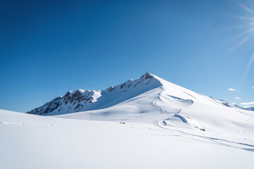 Snow-covered mountain peak under clear blue sky