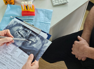 Discussing the problems of a dentist showing x-rays of a patient's jaws and teeth concept