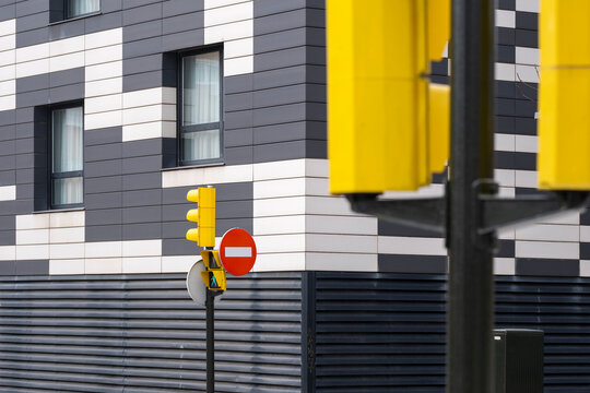 The intersection features vibrant traffic signals against a contemporary building facade, merging urban life with modern architecture and design aesthetics.