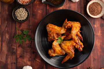 Air Fryer Chicken whole wings (Chicken 3 Joint Wing) with salt in black plate.Crispy and Healthy cooking.Top view.
