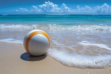 Obraz premium Bright beach ball resting on the sandy shore by calm turquoise waters under a clear blue sky