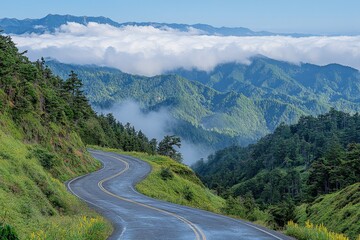 Fototapeta premium Winding road through lush mountains with clouds hovering above in a serene landscape