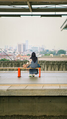 Solitary Train Platform Wait with City Skyline