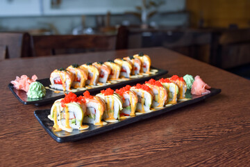 Colorful sushi set with rice. Garnish with pickled ginger and wasabi. Rolled sushi with avocado, mushrooms, tuna, salmon and sesame. With red caviar. Japanese food