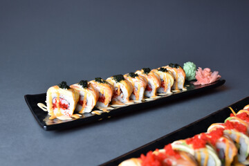 Colorful sushi set with rice. Garnish with pickled ginger and wasabi. Rolled sushi with avocado, mushrooms, tuna, salmon and sesame. With red caviar. Japanese food