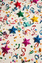 Multicolored confetti stars and curly streamers randomly sprinkled on a crisp white surface for a festive feel