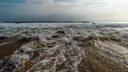 Beach with red sand, red rocks, and a dramatic sky in Congo Town, Monrovia, Liberia