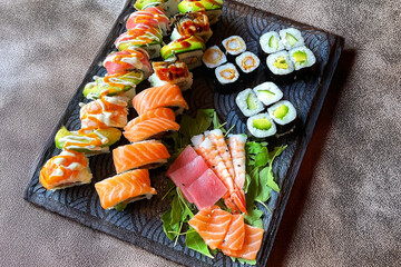 Colorful sushi set with rice. Garnish with pickled ginger and wasabi. Rolled sushi with avocado, mushrooms, tuna, salmon and sesame. With red caviar. Japanese food