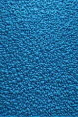 a close up of a blue rug with a lot of small rocks