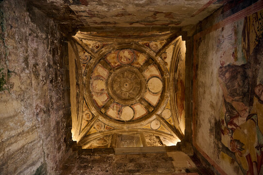 Ornate ceiling artwork with historical fresco details in an ancient architecture
